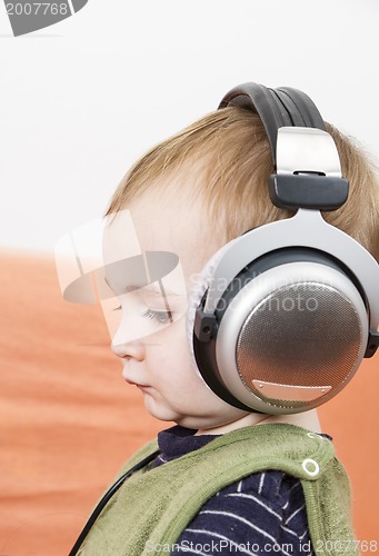 Image of young child on couch with headphone