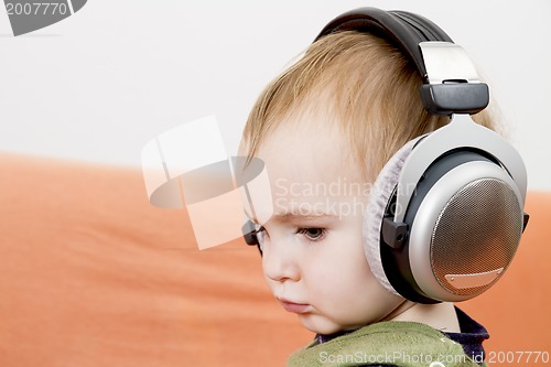 Image of young child on couch with headphone
