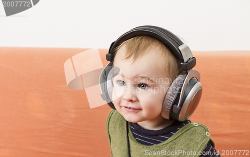 Image of young child on couch with headphone