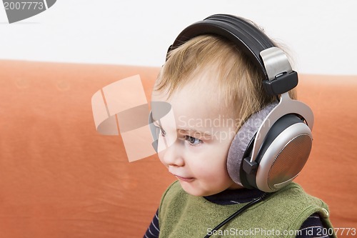 Image of young child on couch with headphone