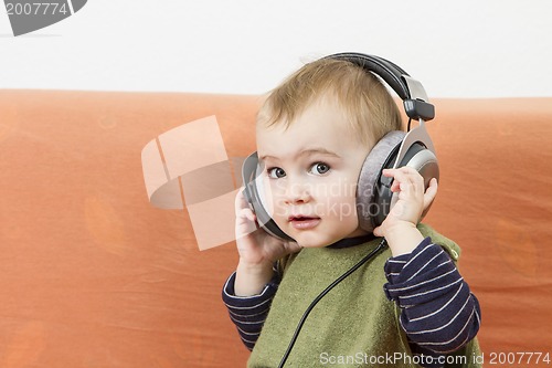 Image of young child on couch with headphone