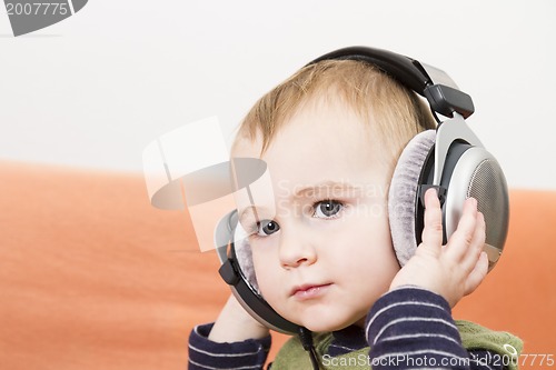 Image of young child on couch with headphone