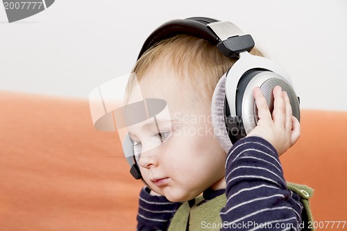 Image of young child on couch with headphone