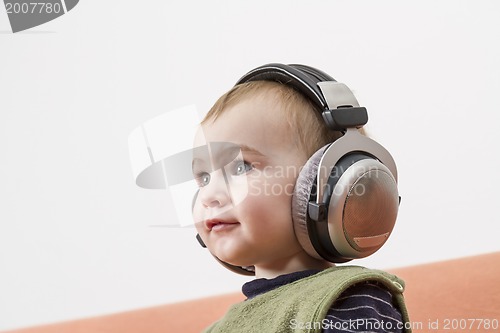 Image of young child on couch with headphone