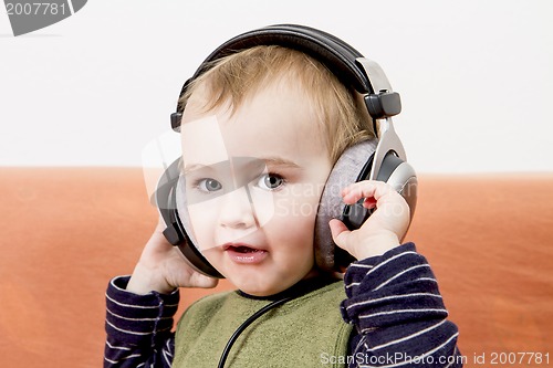 Image of young child on couch with headphone