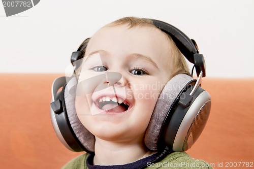 Image of young child on couch with headphone