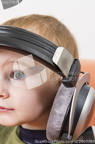 Image of young child on couch with headphone