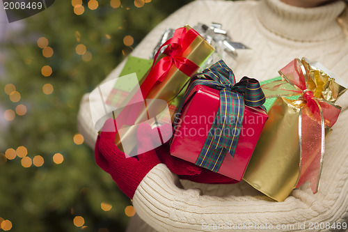 Image of Woman Wearing Seasonal Red Mittens Holding Christmas Gifts