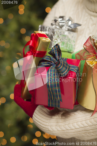 Image of Woman Wearing Seasonal Red Mittens Holding Christmas Gifts