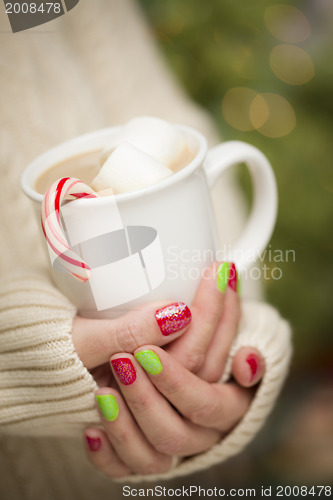 Image of Woman with Red and Green Nail Polish Holding Cup of