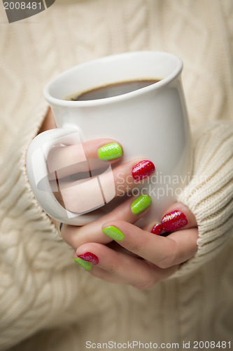 Image of Woman with Red and Green Nail Polish Holding Cup of Coffee