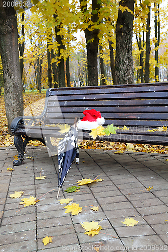 Image of Santa's cap and an umbrella on a bench. 