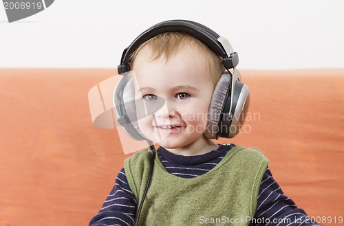 Image of young child on couch with headphone