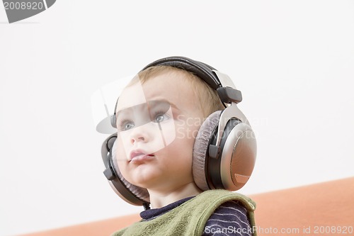 Image of young child on couch with headphone