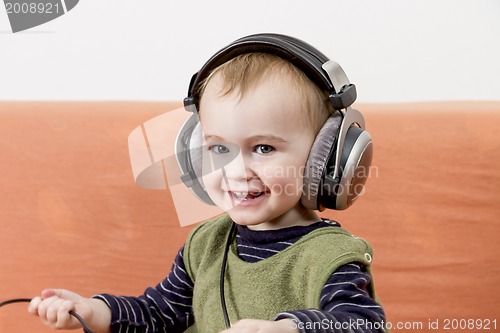 Image of young child on couch with headphone