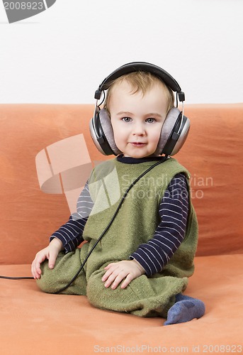 Image of young child on couch with headphone