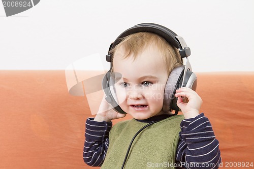 Image of young child on couch with headphone