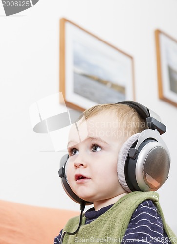 Image of young child on couch with headphone