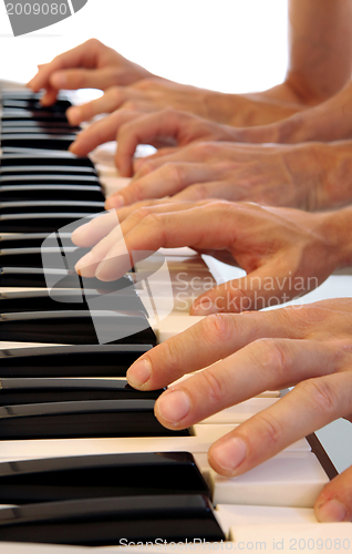 Image of Six hands on grand piano