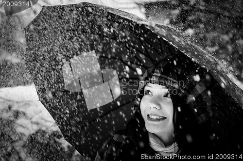 Image of Young woman with umbrella in a blizzard