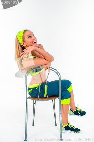 Image of Young fitness instructor sitting on chair