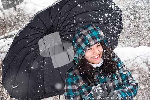 Image of Girl with umbrella in the snow