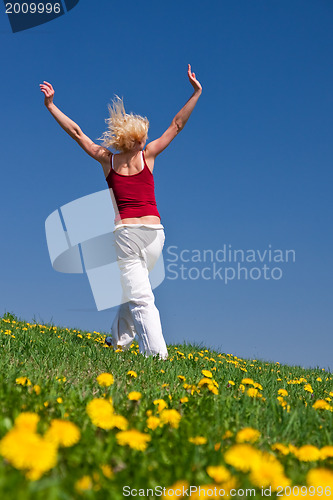 Image of young woman in red outfit having fun on meadow