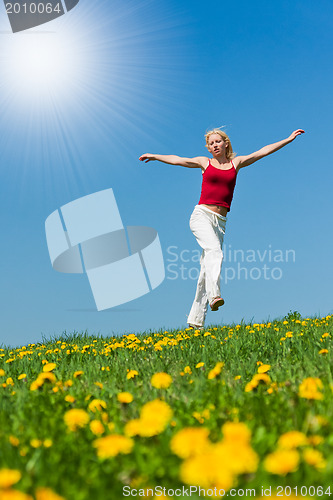 Image of young woman in red outfit having fun on meadow