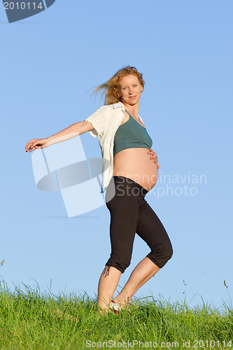 Image of pregnant woman on meadow