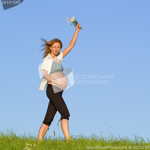 Image of pregnant woman on meadow