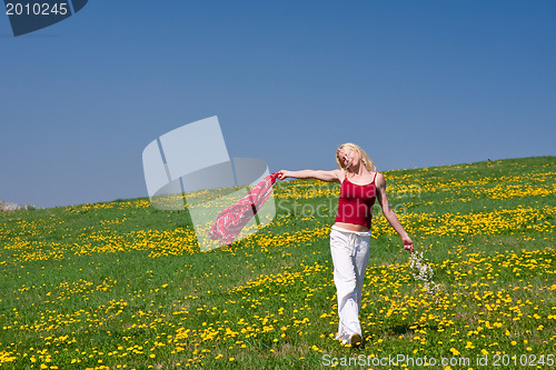 Image of young woman with a red scarf on a meadow