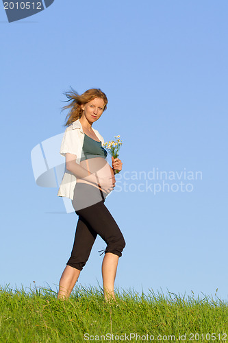 Image of pregnant woman on meadow