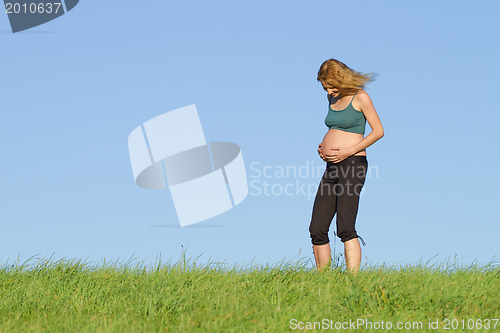 Image of pregnant woman on meadow