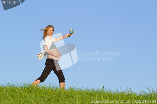 Image of pregnant woman on meadow