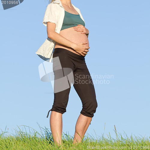 Image of pregnant woman on meadow