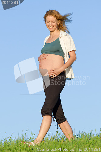 Image of pregnant woman on meadow