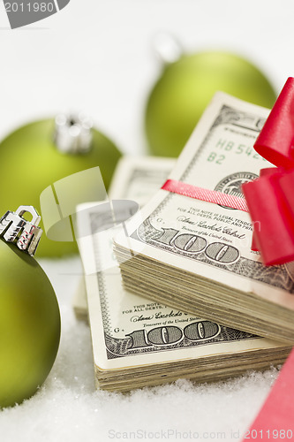 Image of Stack of Hundred Dollar Bills with Bow Near Christmas Ornaments