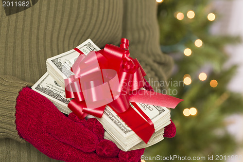 Image of Woman Wearing Mittens Holding Stacks of Money with Red Ribbon