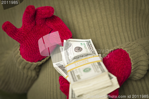 Image of Woman Wearing Mittens Holding Stacks of Money with Red Ribbon