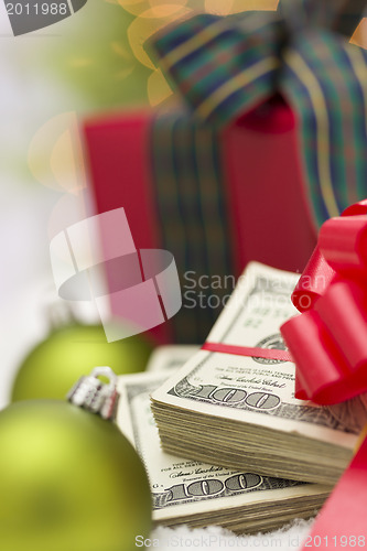 Image of Stack of Hundred Dollar Bills with Bow Near Christmas Ornaments