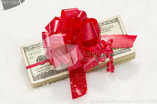 Image of Stack of Hundred Dollar Bills with Red Ribbon on Snow