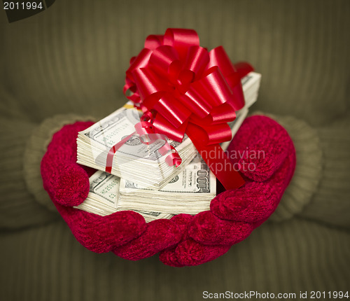 Image of Woman Wearing Mittens Holding Stacks of Money with Red Ribbon