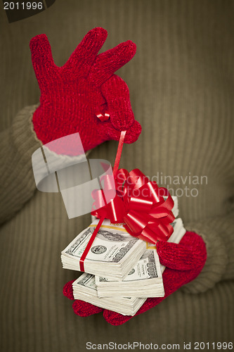 Image of Woman Wearing Mittens Holding Stacks of Money with Red Ribbon