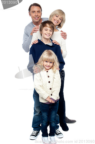 Image of Affectionate family of four standing in a row