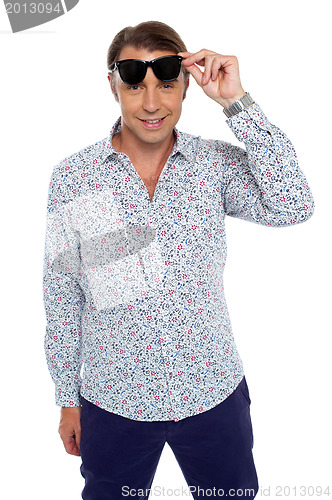 Image of Confident casual man taking off his dark shades