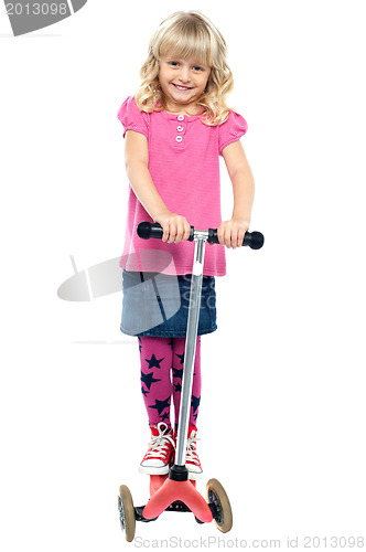 Image of Happy little girl riding her scooter