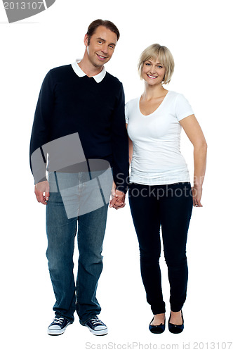 Image of Middle aged couple posing with hand in hand