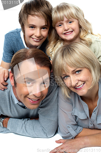 Image of Parents lying down with children on top