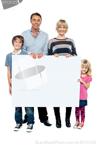 Image of Active young family displaying blank ad board
