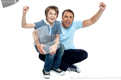 Image of Joyous father and son cheering loud